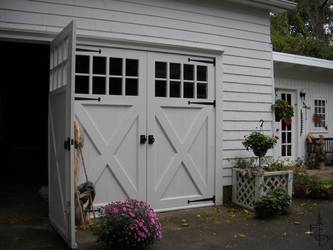 OL8X - Evergreen's 8 lite carriage doors with crossbucks enhance this farm house.