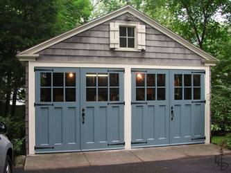 Carriage doors painted colonial blue restore the historic character of this detached carriage house.