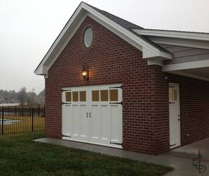 New brick carriage house with OL3L Olympic style carriage doors and a matching custom entry door